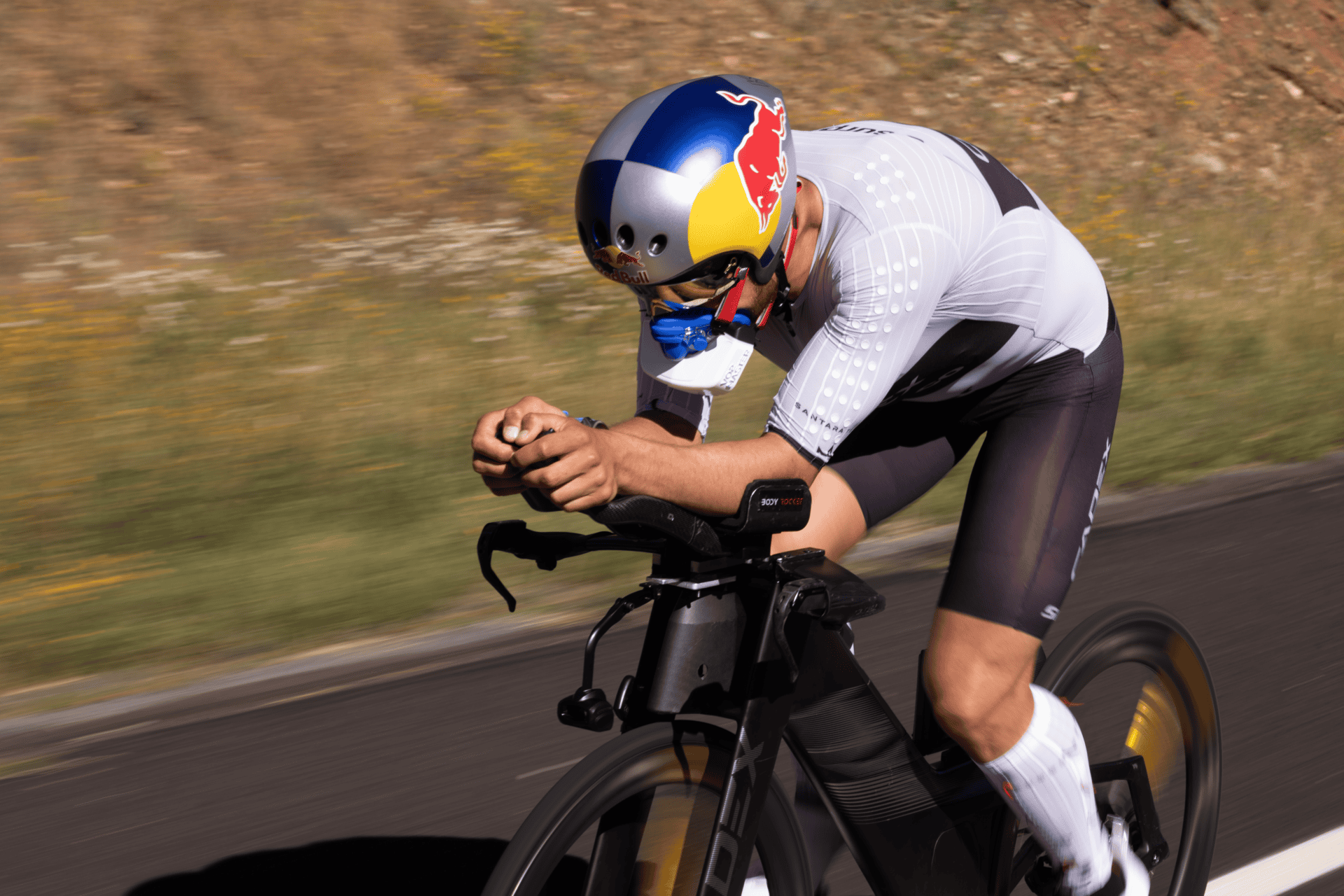 Biker riding outdoors with Red Bull helmet and VO2 Master analyzer