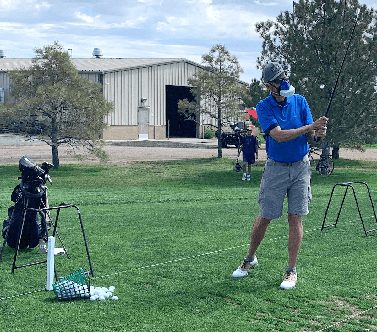 A golfer at the range using the VO2 master portable metabolic analysis during a study to determine energy expenditure during range practice