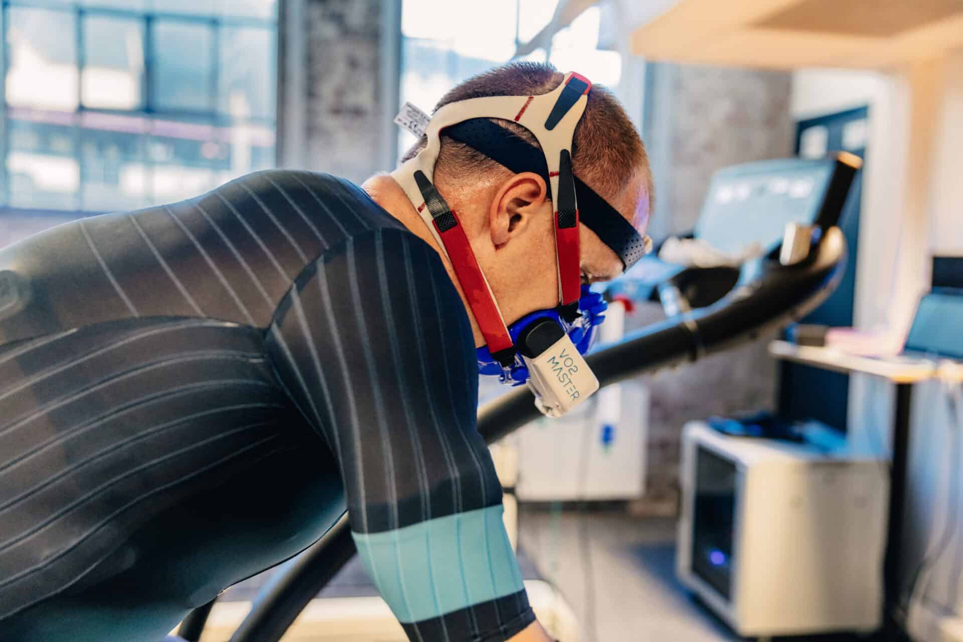 A man on training bike in a lab wearing VO2 Master for metabolic testing