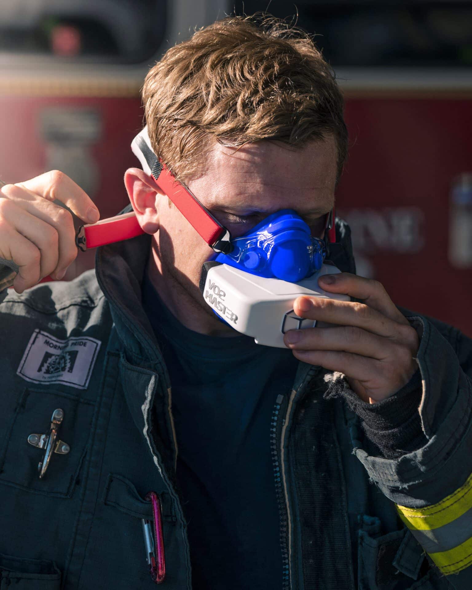 Firefighter in full gear strapping on the VO2 Master Analyzer and mask