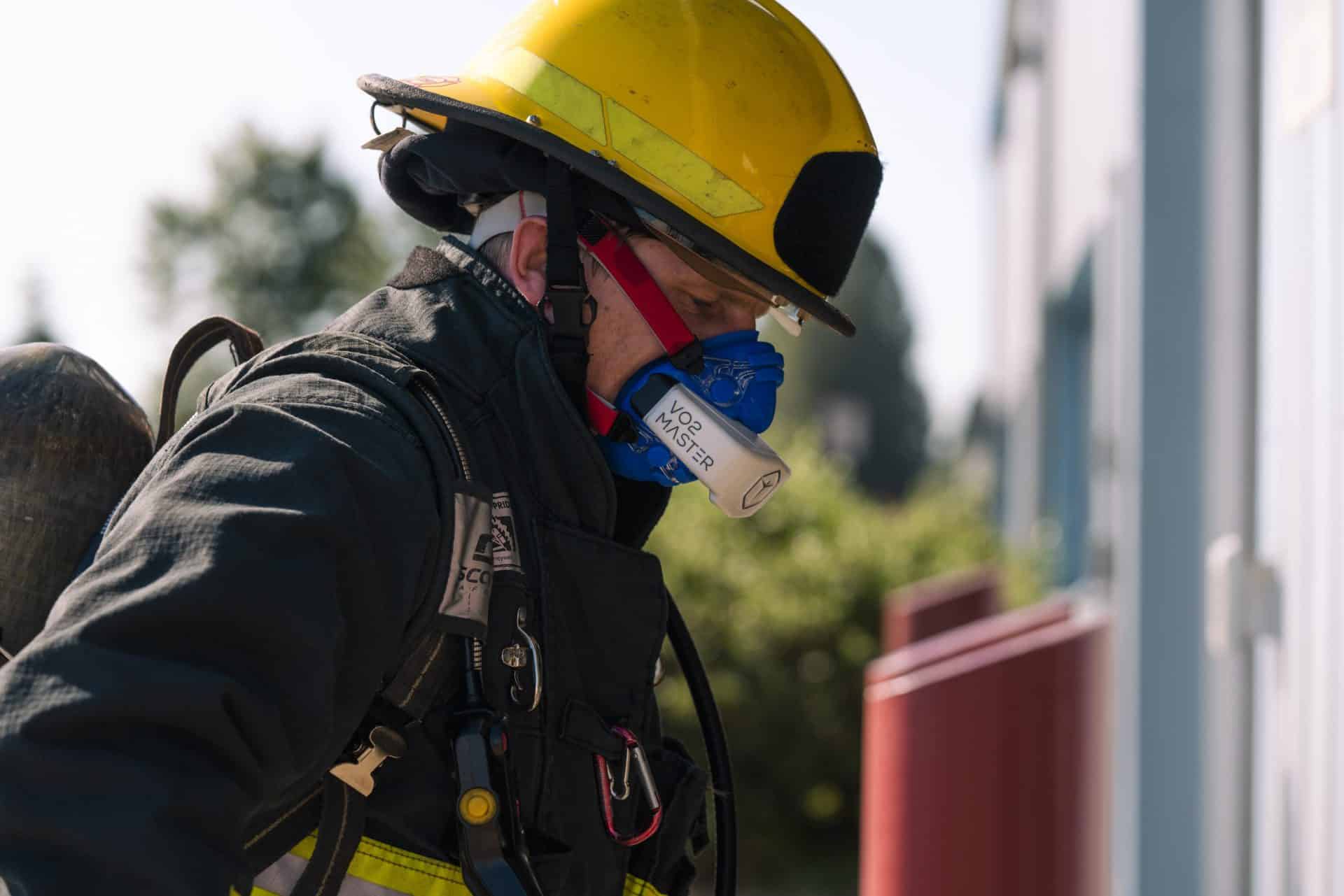 Firefighter in full gear using a VO2Master Analyzer for a high-intensity training session