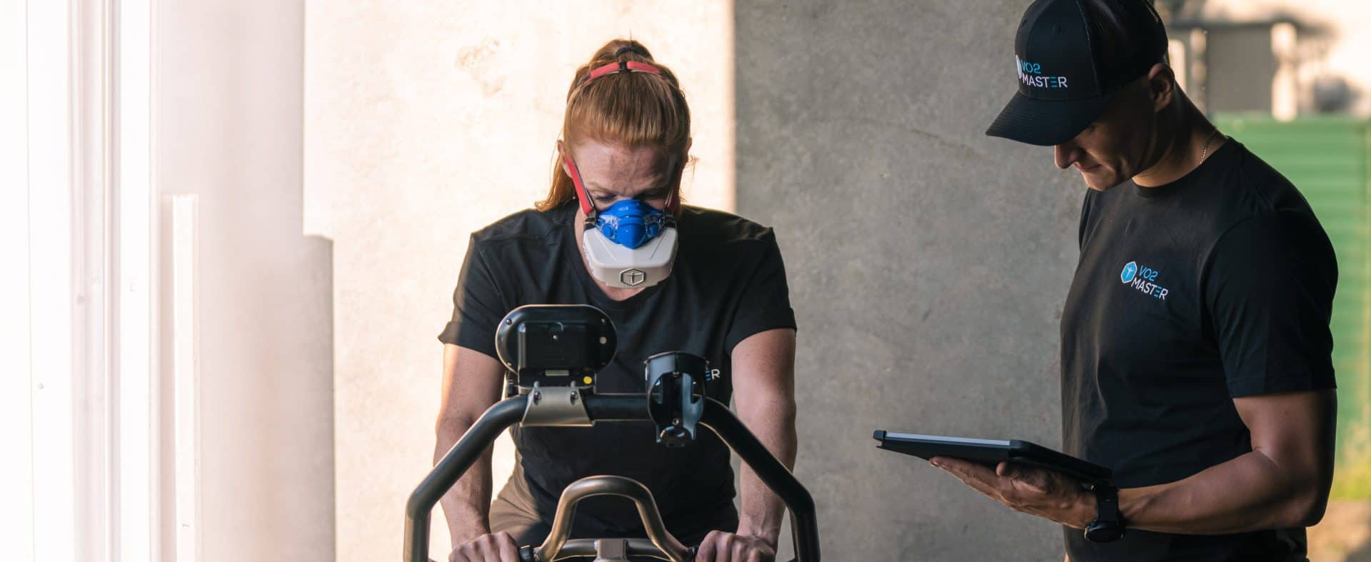 Woman biking inside a fitness facility with the metabolic and RMR analyzer