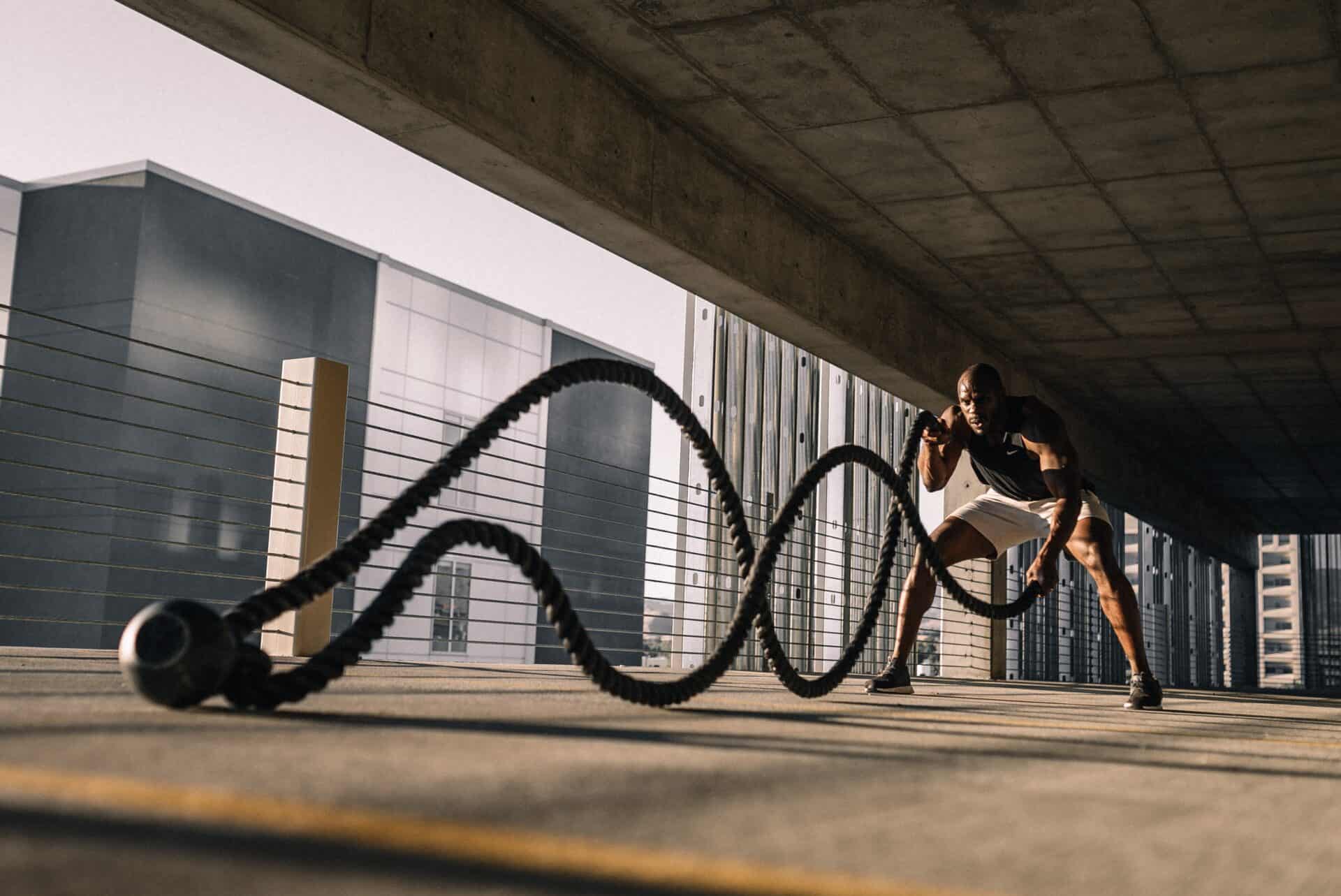 A man using battle ropes in a high-intensity work out.