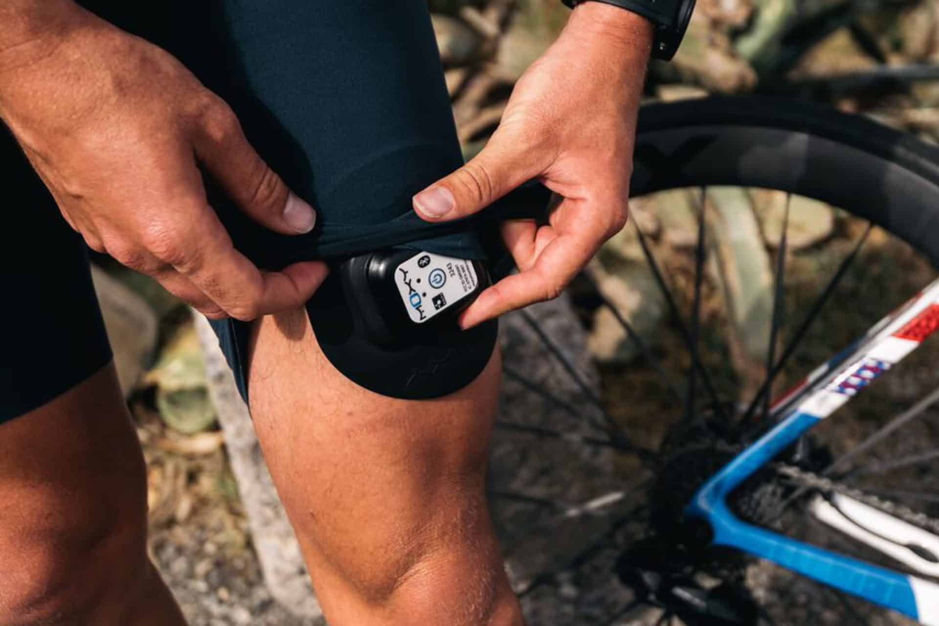 a cyclist with a moxy monitory on his thigh