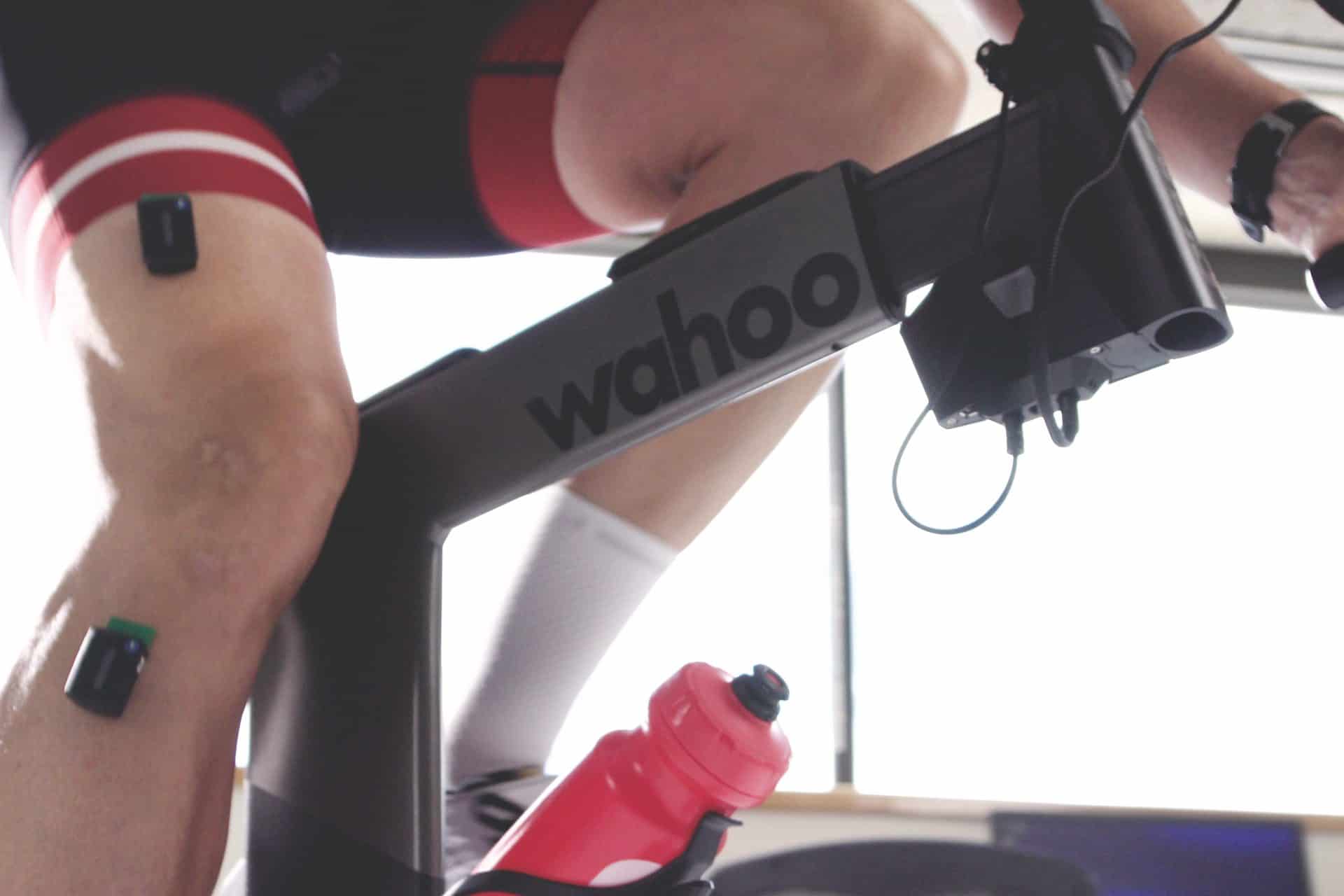 a cyclist with sensors on his legs training on a wahoo indoor training bike